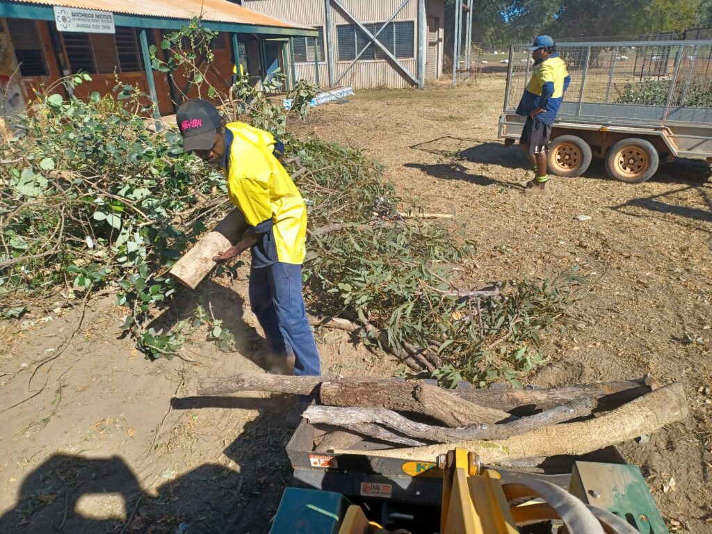Barunga men clearing debris and wood